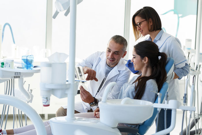 dentist-and-his-assistant-in-the-dental-office-talking-with-a-young-patient