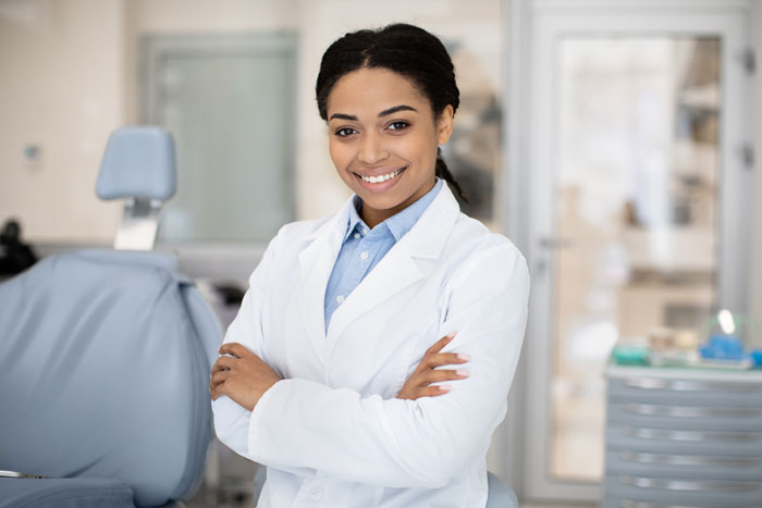 portrait-of-an-odontologist-woman-black-happy-on-her-feet-with-crossed-arms